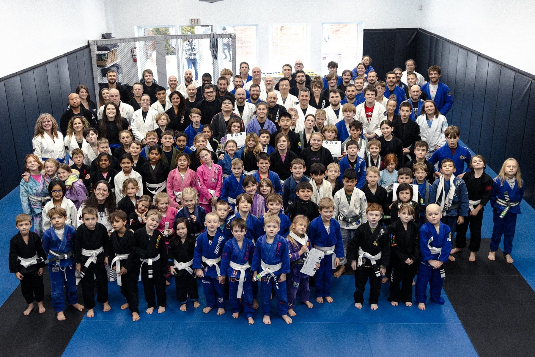 The whole Woodstock BJJ academy, kids and adults together, lined up on the mats