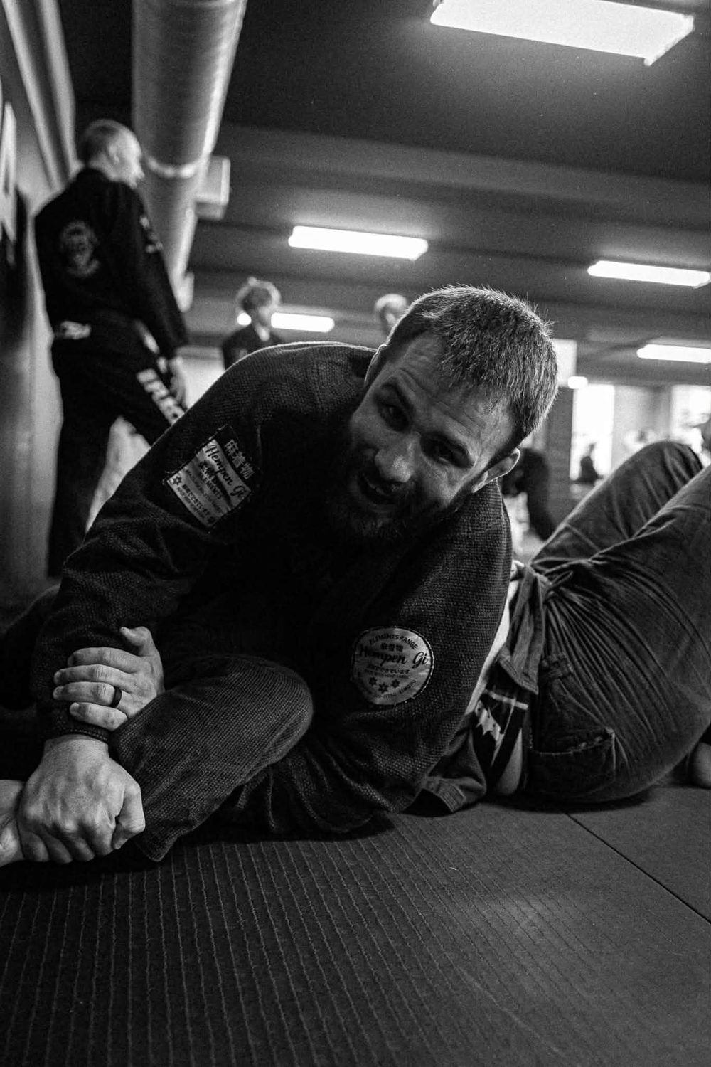 Two adults training a ground position under control at Woodstock BJJ